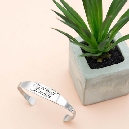 Inspirational stainless steel cuff bracelet with engraved words 'Forever Friends' on the outside. Adjustable and hypoallergenic, perfect as a thoughtful gift for friends.