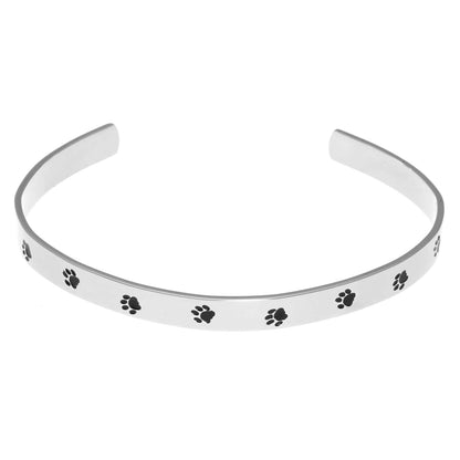 Stainless steel cuff bracelet with a minimalistic pet paw print design, featuring the inscription 'Unconditional Love' on the inside.