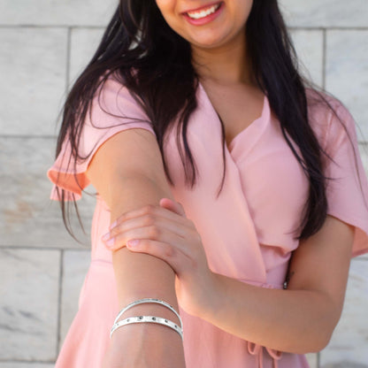 Stainless steel cuff bracelet with a minimalistic pet paw print design, featuring the inscription 'Unconditional Love' on the inside.