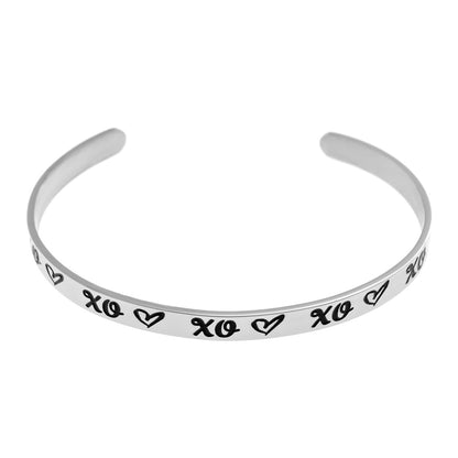 Inspirational stainless steel cuff bracelet with repeating XO's and hearts on the outside and engraved words 'My maid of honor today, my sister forever' on the inside. Adjustable and hypoallergenic, perfect as a thoughtful gift for sisters and symbolizing the bond of sisterhood.