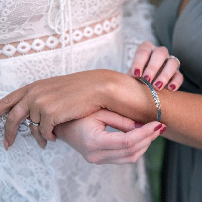 Inspirational stainless steel cuff bracelet with an elegant Victorian flower design on the outside and engraved words 'My maid of honor today, my sister forever' on the inside. Adjustable and hypoallergenic, perfect as a thoughtful gift for sisters and symbolizing the enduring bond of sisterhood.